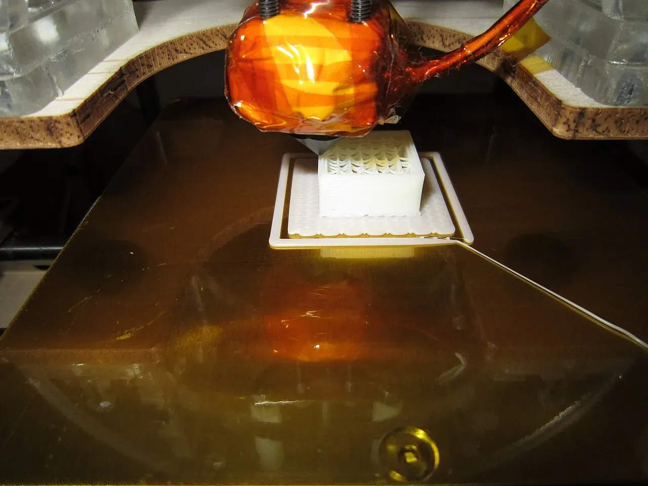 A 20 mm calibration cube being printed under a hotend