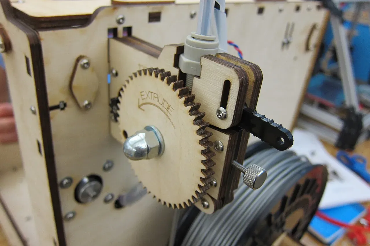 Close-up of a wooden Ultimaker extruder with a large drive gear