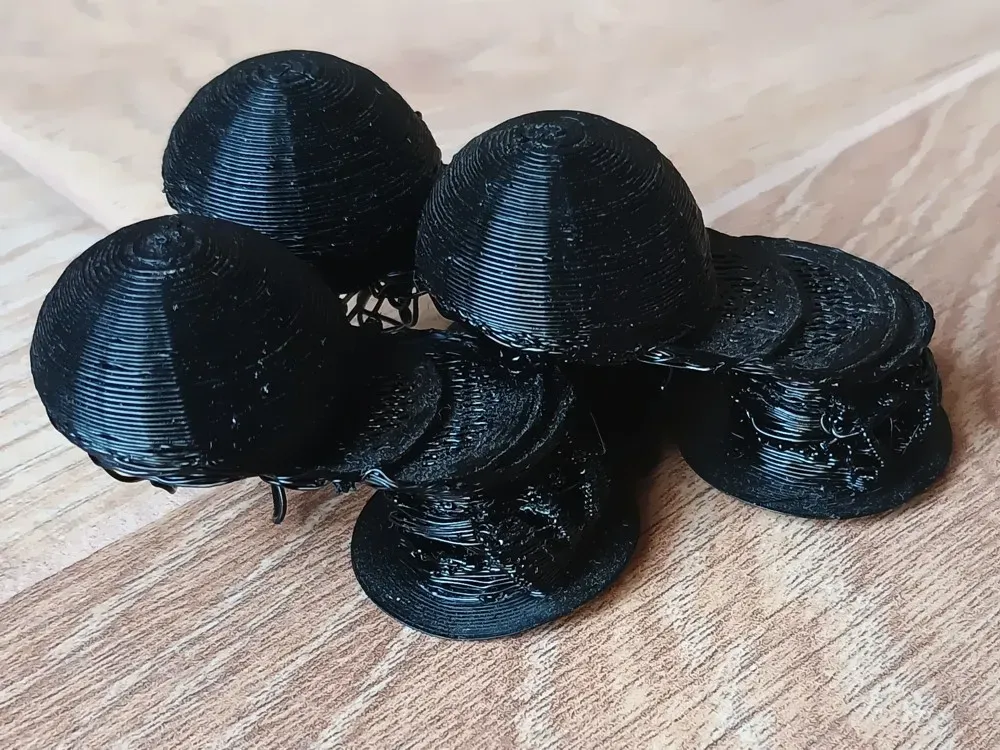 Black dome prints with visible layer shifts partway up