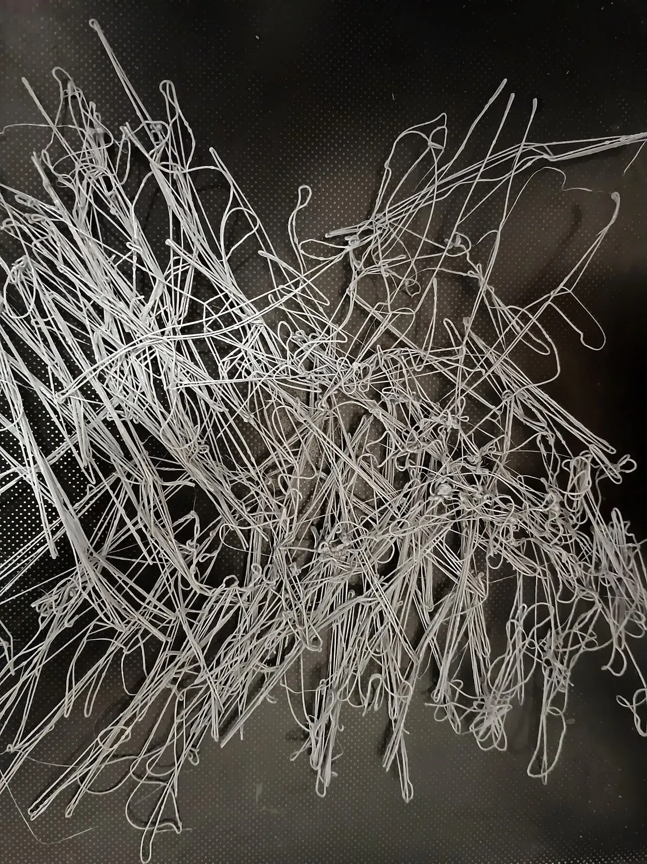 A large nest of loose white filament strands from a failed print