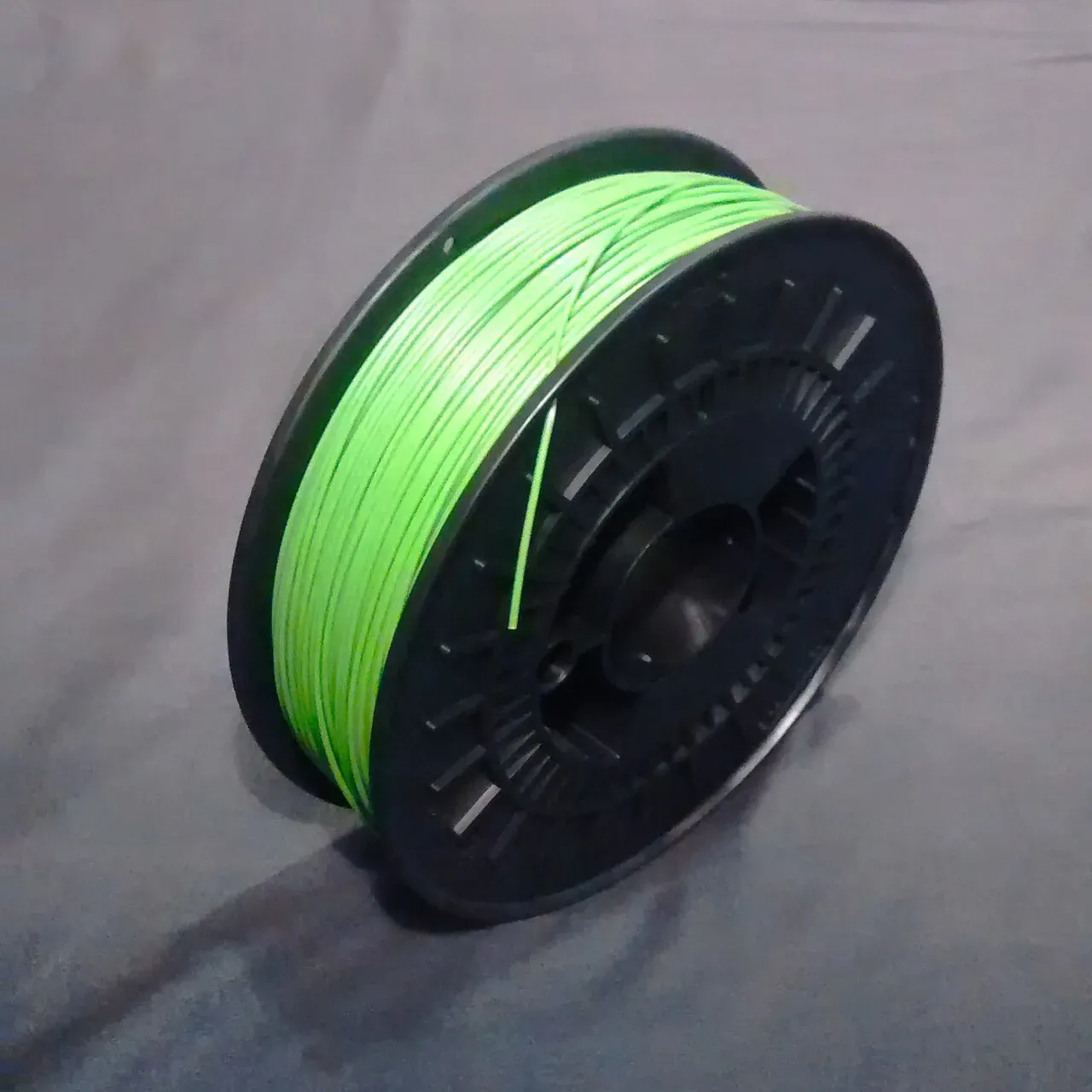 A green spool of ABS filament