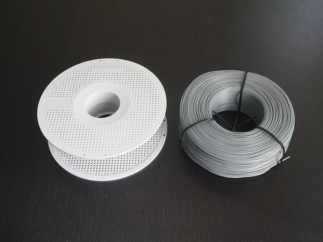 A reusable spool next to a coil of refill filament