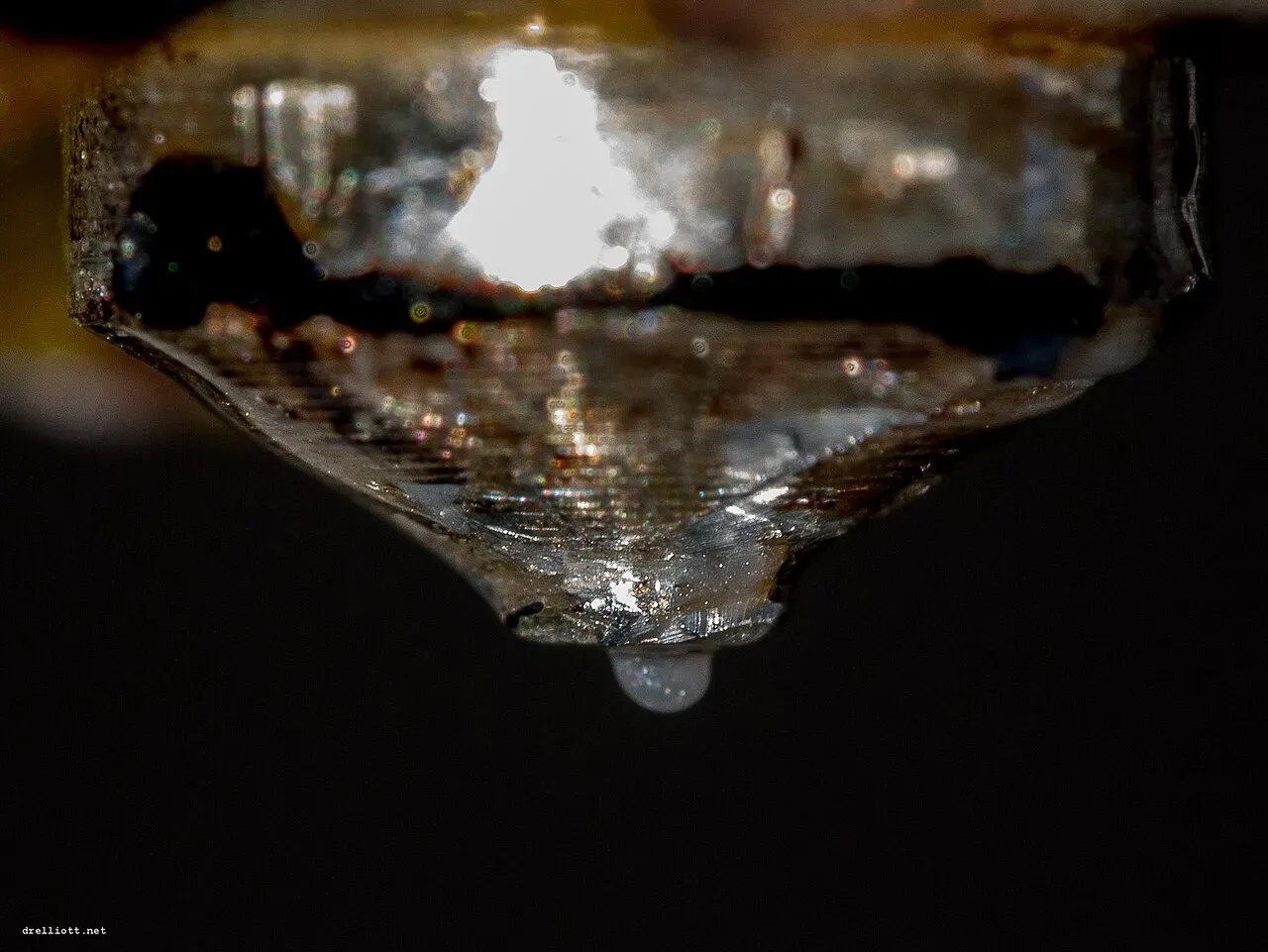 A drop of molten plastic hanging from a nozzle tip