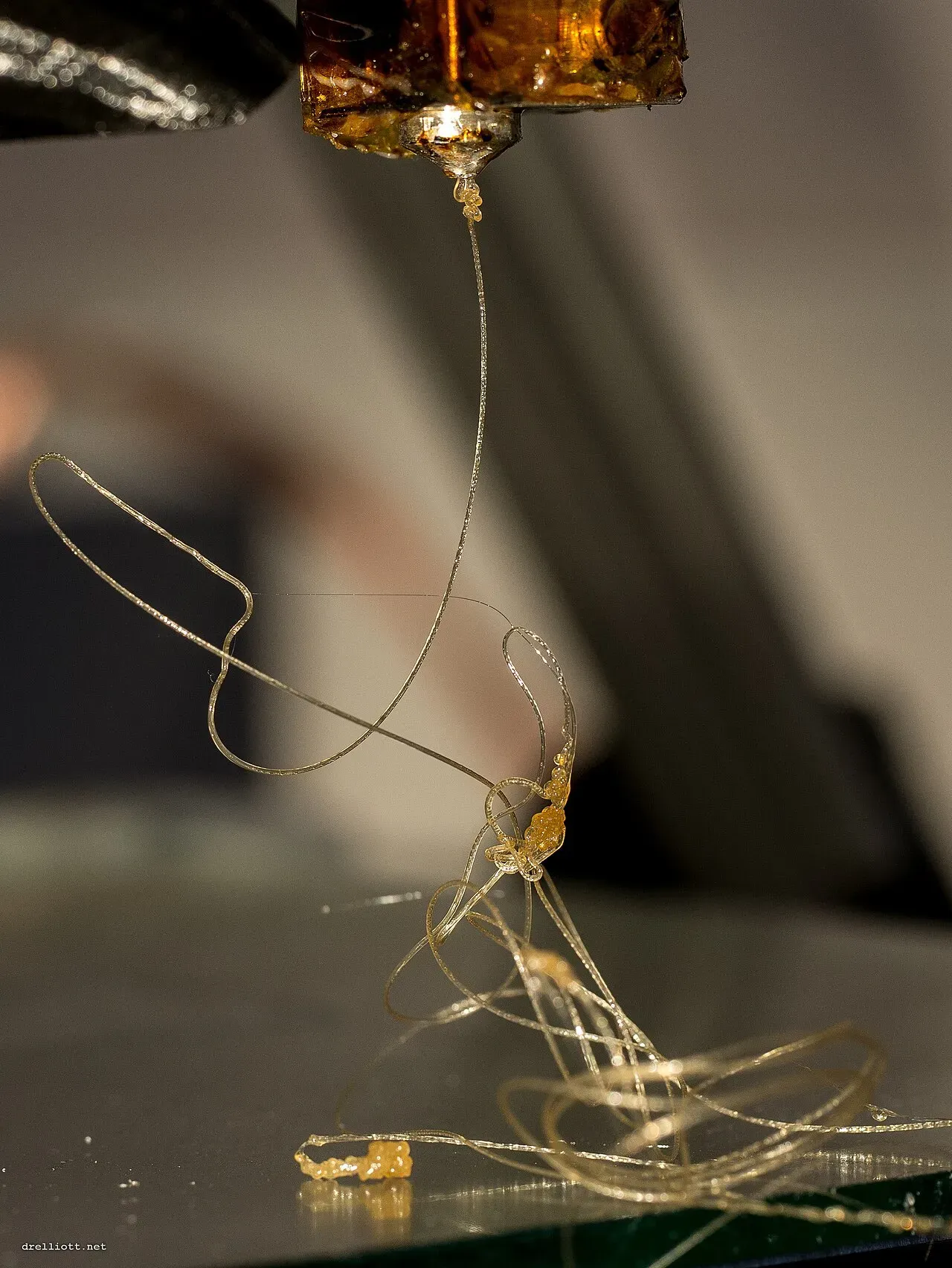 A thin strand of plastic trailing from a nozzle