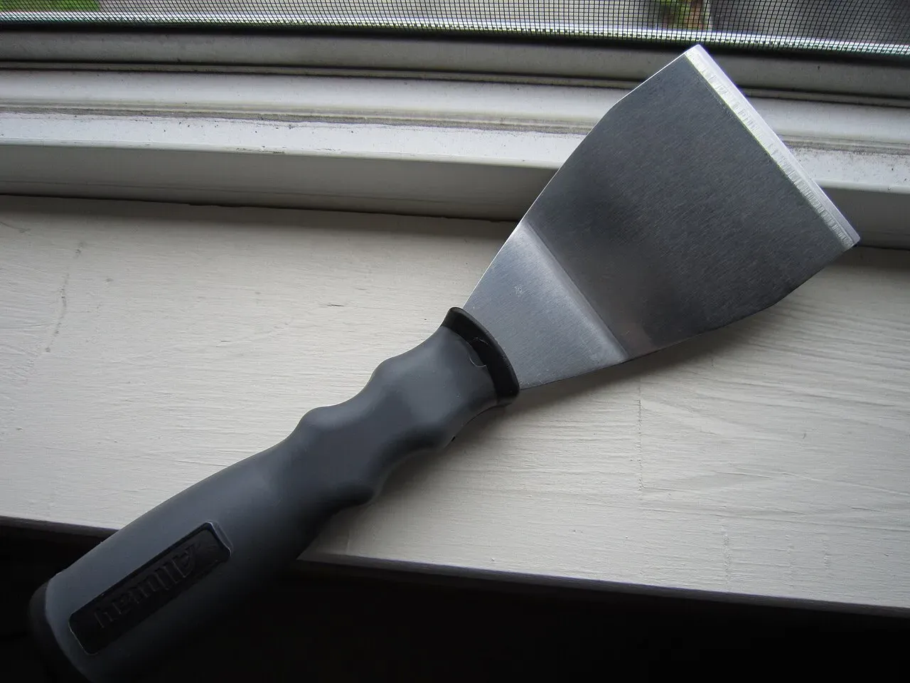 A grey print scraper tool