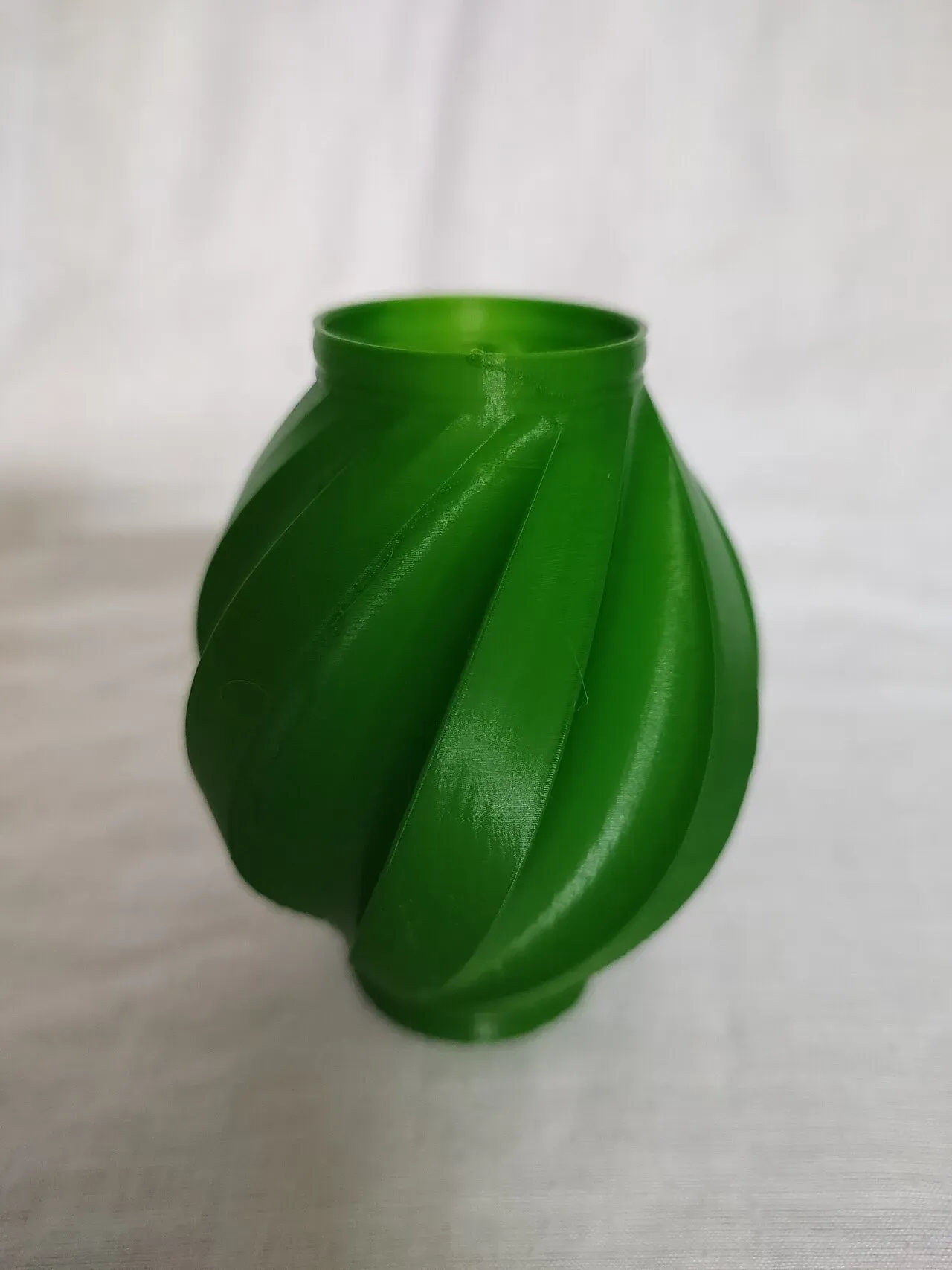 A green twisted printed vase