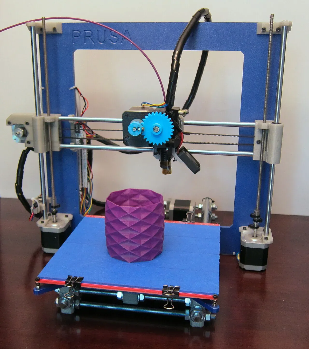 A Prusa i3 with a metal frame printing a purple vase