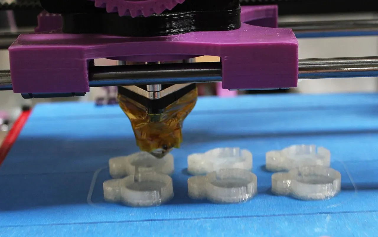A printer head laying down plastic over small parts